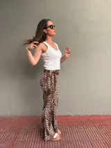 Cinto marrón con textura símil cuero, argollas plateadas y lazos de ajuste.