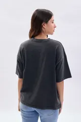 Remera de manga corta con efecto de lavado desgastado en color gris oscuro, de corte holgado y cuello redondo.
