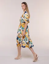 Vestido midi de calce holgado y caída fluida con escote en V cruzado, cintura elastizada fruncida y mangas cortas con volados superpuestos. Cuenta con un diseño estampado de flores grandes en tonos amarillo, blanco, azul marino y verde.