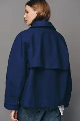 Cazadora de cuello solapa y manga larga, color azul, con diseño cruzado y cierre frontal con botones.