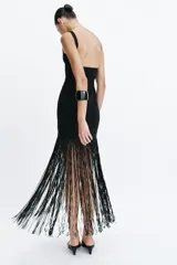 Vestido largo entallado negro con escote cuadrado, tirantes anchos y bajo acabado en flecos largos a tono.