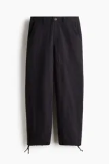 Pantalón de corte relajado confeccionado en tejido ripstop resistente. Presenta cierre con botón, bolsillos laterales al bies y bolsillos traseros de parche. Incluye costuras horizontales en las piernas y cordón ajustable en los bajos.