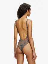 Traje de baño enterizo con diseño de camuflaje en tonos verdes y marrones. Presenta un corte cavado, escote redondo y un detalle metálico con el logo de la marca en el centro del pecho.