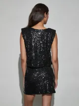 Top de lentejuelas negro sin mangas, corte recto y corto tipo crop top.