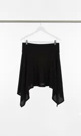 Falda negra de algodón con bajo irregular y faja ajustable.