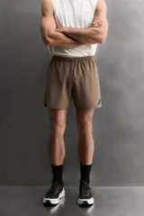 Short deportivo Zara Athleticz color marrón, de tejido técnico ligero y elástico con cintura elástica ajustable con cordón y detalles de bolsillos.