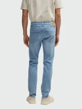 Jeans de corte slim fit en color azul claro con efecto lavado. Presenta cierre de botón y cremallera, cinco bolsillos clásicos y costuras reforzadas.