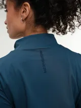 Campera deportiva marrón con cuello alto y cierre frontal completo. Presenta mangas largas con orificio para el pulgar y corte ajustado.