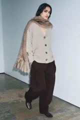 Chaqueta de punto color beige, confeccionada en 100% lana, con escote en pico, manga larga y cierre frontal con botones.