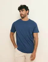 Remera básica de algodón color beige, de manga corta, con cuello redondo y un pequeño detalle bordado en el pecho.