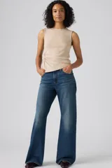 Jeans de denim azul de corte amplio y bota ancha, tiro medio, con efecto ligeramente lavado en las piernas y diseño clásico de cinco bolsillos.