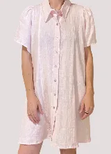 Vestido camisero blanco de lino con cuello clásico, cartera a la vista, mangas cortas acampanadas y bordados de motivos marinos.