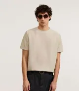 Remera masculina de manga corta, cuello redondo y textura acanalada, color beige claro.