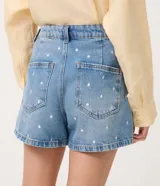 Short de jean color azul con corte evasé y bordado de lunares blancos en toda la prenda. Cuenta con pasacintos, bolsillos delanteros y traseros.