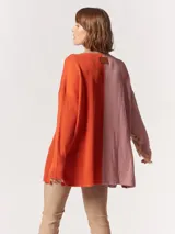 Buzo tejido oversized con bloques de color blanco y gris, cuello redondo en verde neón, tajos laterales y flecos verdes en las mangas.