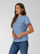 Remera celeste de manga corta, con cuello redondo y pequeño gráfico estampado en el lado izquierdo del pecho.