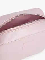 Cartera tipo bandolera de Tommy Jeans con acabado brillante y liso. Presenta un diseño compacto con cierre de cremallera y una insignia con el logo de la marca grabado en el frente.