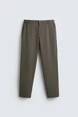 Pantalón de corte slim fit confeccionado en tejido elástico, con cintura elástica, cierre frontal con cremallera y botón, bolsillos laterales y bolsillos traseros de vivo.