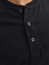 Remera básica de cuello mao y mangas cortas, color negro, con cierre frontal parcial de botones.