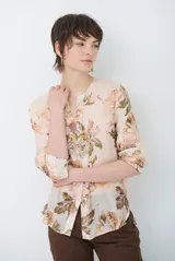 Camisa de manga larga color salmón con estampado floral en tonos marrones y verdes, cuello mao y cierre frontal con botones.
