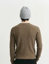 Sweater de punto con textura waffle, color negro, de corte clásico con cuello redondo y mangas largas con puños ajustados.