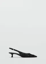Zapato tipo slingback color negro con punta fina y tacón kitten de 5 cm. Confeccionado en tejido de malla con bordados de lentejuelas y cierre de tira con hebilla ajustable.