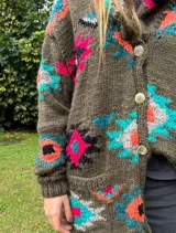 Saco tejido a mano de color negro, con diseño geométrico multicolor, cuello smoking y cierre frontal con dos botones.