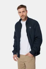 Campera liviana de color verde grisáceo, con cierre frontal, cuello alto y puños elásticos. Presenta un pequeño parche con logo en el pecho.