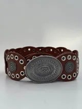 Cinto marrón de cuero con apliques metálicos plateados y hebilla ovalada con diseño floral.