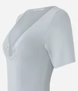 Blusa de manga corta confeccionada en tejido de viscosa texturizado, con escote en V profundo que presenta un detalle de aro metálico central.