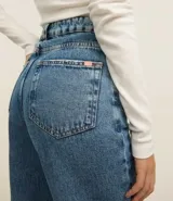 Pantalón de jean celeste de corte wide leg, cintura alta con elástico negro y pespuntes contrastantes.