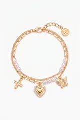 Pulsera de doble cadena dorada con perlas cultivadas intercaladas. Presenta tres dijes colgantes: una cruz, un corazón con borde de cristales y una mariposa. Incluye cierre de mosquetón con cadena de alargue y dije circular con logo grabado.