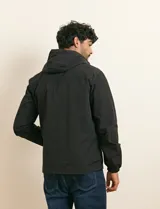 Campera impermeable gris con capucha, cierre frontal y bolsillos laterales con cremallera.