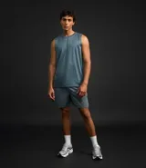 Musculosa deportiva masculina color beige, con cuello redondo y estampado sutil de líneas. Presenta recortes en los hombros y está confeccionada con tecnología Dry para mayor transpirabilidad.