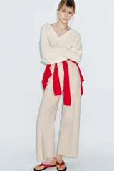 Jeans de tiro alto confeccionados en mezcla de algodón, con diseño de pierna ancha y costura marcada en el delantero. Presenta cintura con trabillas, cierre frontal con cremallera, botón y gancho metálico, y bolsillos de plastrón en la espalda.