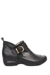 Botín negro de cuero liso con elástico lateral, hebilla decorativa y suela con cámara de aire.