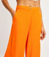 Pantalón modelo pantalona de corte amplio, confeccionado en una mezcla de viscosa y lino. Presenta cintura con botón, cierre de cremallera y bolsillos laterales.