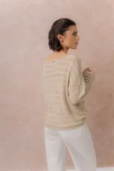 Sweater tejido calado color beige, con escote amplio y mangas largas de calce relajado.