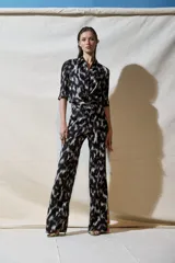 Camisa de viscosa crepe con estampado abstracto en blanco y negro, cuello camisero, mangas cortas abullonadas y cierre frontal con botones.