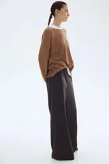 Pantalón de tejido de punto pesado color gris oscuro, tiro alto con elástico oculto en la cintura y piernas rectas con pliegues marcados.