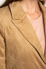 Blazer negro de textura gamuzada con solapas clásicas, cierre frontal de dos botones y bolsillos laterales con solapa.