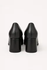 Zapatos de tacón alto de cuero negro, con punta cuadrada y taco bloque forrado.