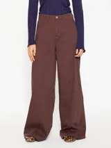 Pantalón de jean color marrón, de corte wide leg, con cinco bolsillos y recortes diagonales en las piernas.