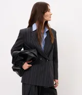 Blazer oversized de sastre Cortelle, color negro con diseño a rayas, cierre cruzado de doble botonadura y solapas clásicas.