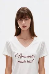 Remera negra de algodón, con cuello en V, mangas cortas, corte al cuerpo y estampa frontal con la frase "Emotionally Unavailable" en letras rosadas.