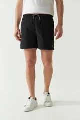 Short de baño liso de corte clásico, con cintura elástica ajustable mediante cordón. Cuenta con dos bolsillos laterales y uno trasero, confeccionado en tejido ligero de secado rápido con logo bordado.