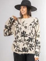 Sweater de punto con calce oversized, fondo color crudo y diseño estampado de flores en color negro. Presenta cuello redondo y mangas largas.