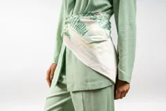 Pañuelo cuadrado de seda con estampado artístico de paisaje con cipreses en tonos verdes y crema. Incluye el logo de la marca Nubia en una de sus esquinas.