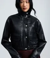 Campera bomber de poliuretano con cuello alto estructurado, cierre frontal con botones de presión, bolsillos utilitarios delanteros y ruedo con elástico para un ajuste cómodo.