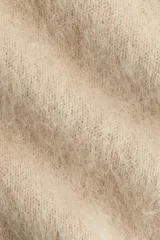 Buzo oversized de punto suave confeccionado en mezcla de lana y mohair. Presenta un diseño de hombros caídos, cuello redondo y terminaciones acanaladas en cuello, puños y bajo.